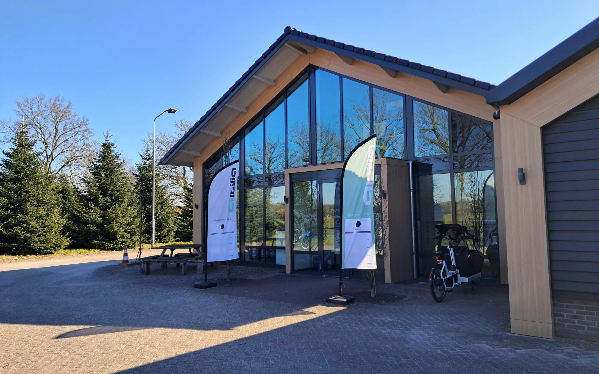 Het pand van Altilia in Renswoude met glazen puntgevel en beachflags in de zon