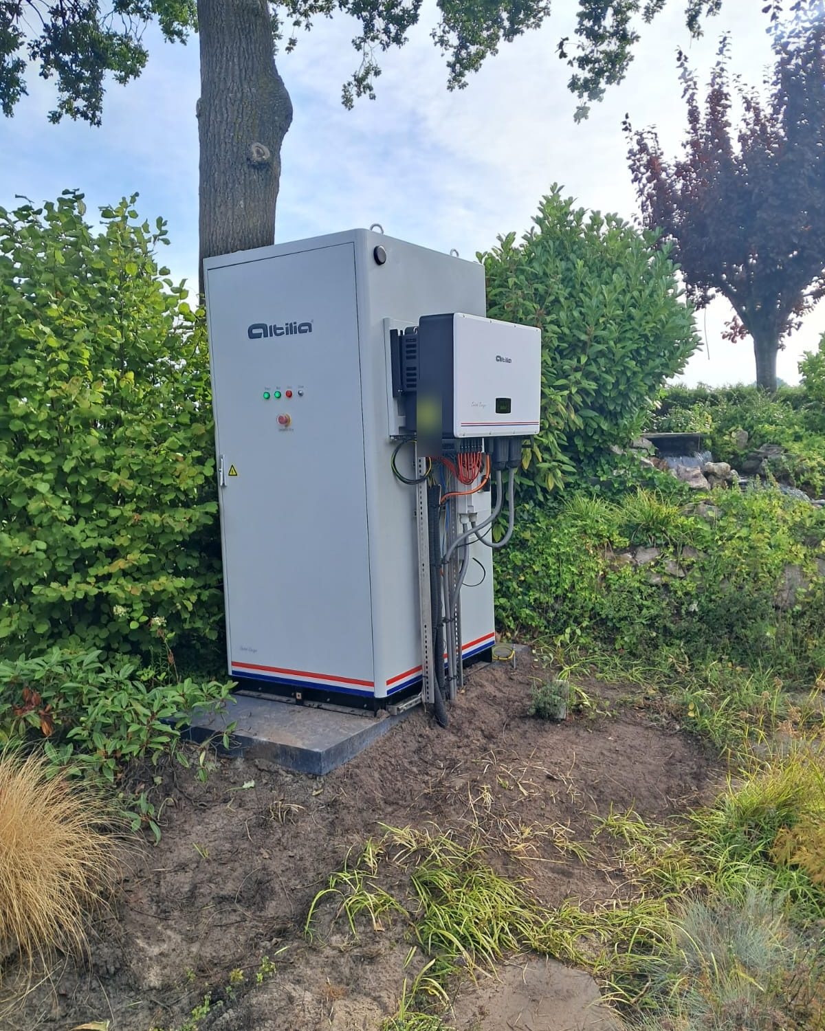 Energieopslagsysteem van Altilia tussen het groen in een tuin