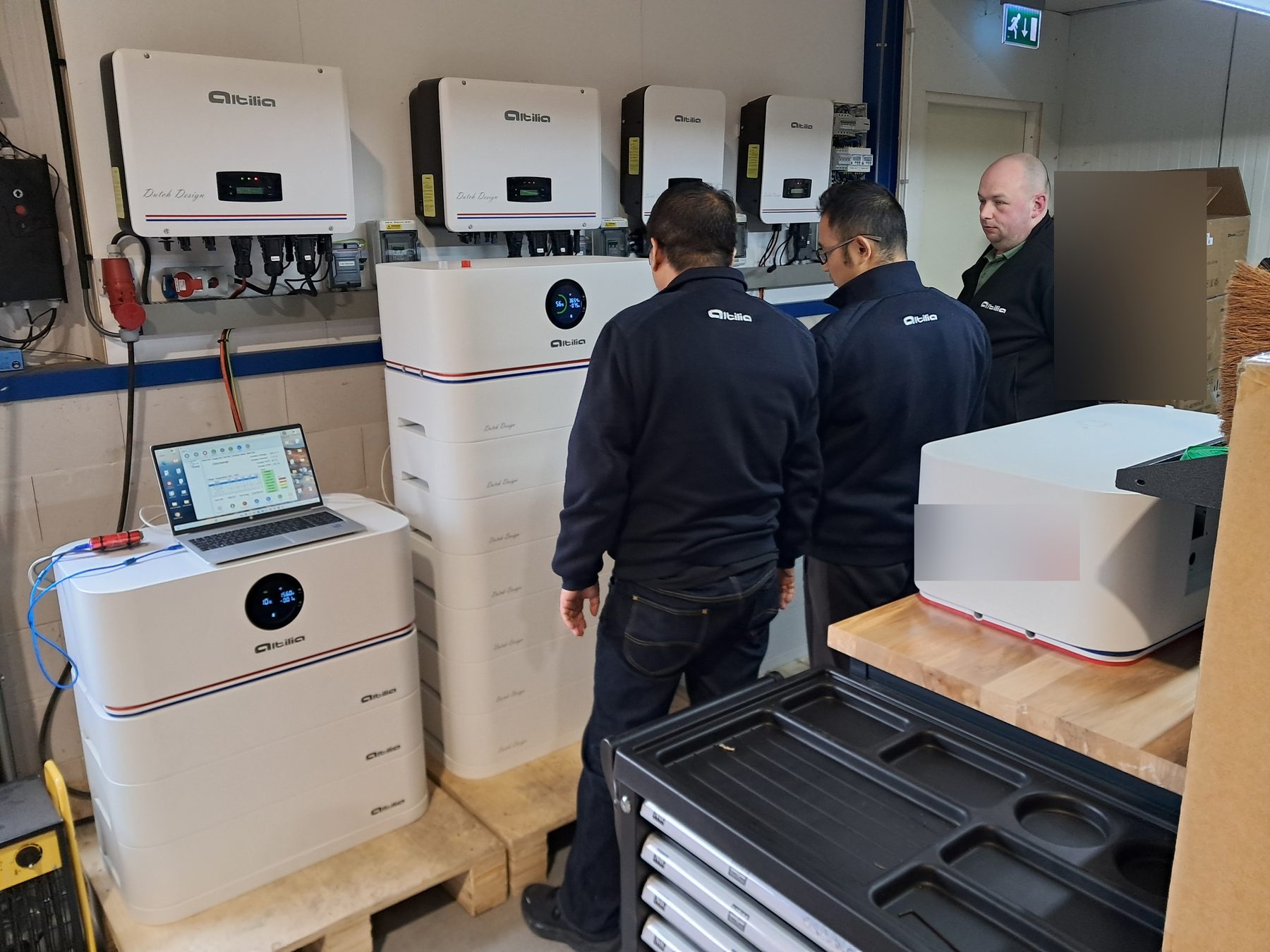 Batterijen en omvormers worden met een laptop doorgemeten in de testruimte