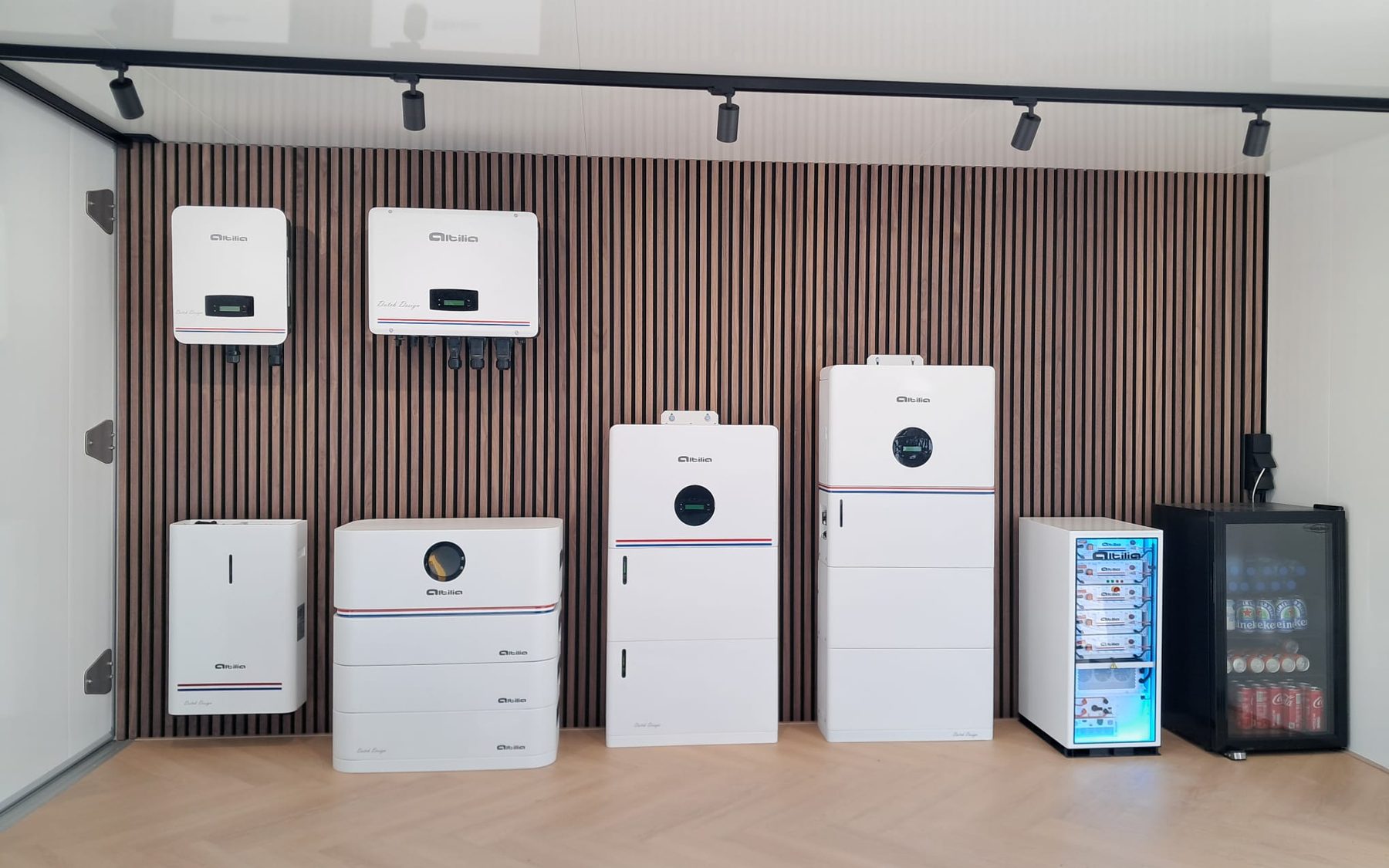 De productwand in de showroom: omvormers, thuisbatterijen en energieopslagsystemen tegen een houten latwand