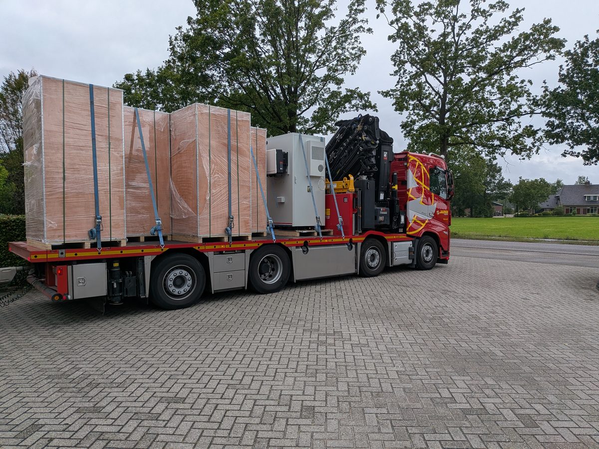 Kraanwagen met kisten en een energieopslagsysteem op de laadvloer